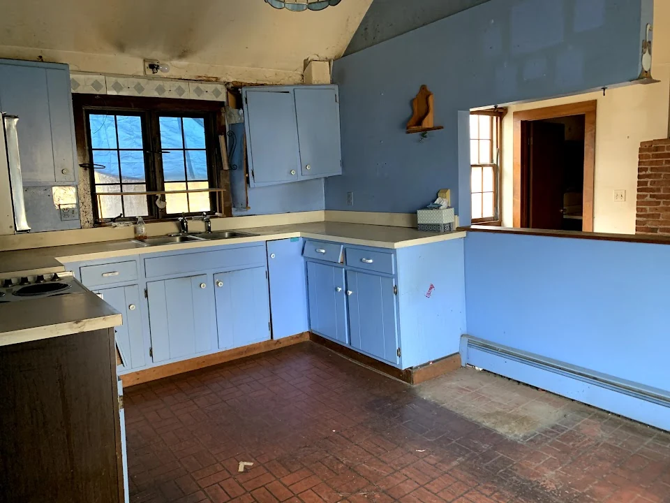 Dart Hill kitchen before renovation, with blue cabinets and an unfinished ceiling.