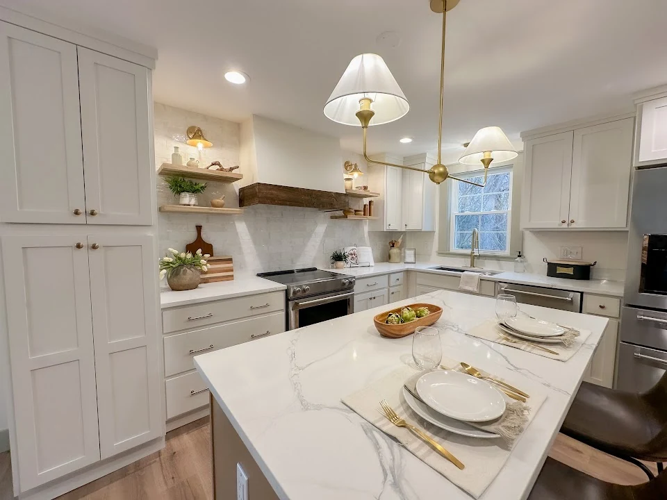 Main Street kitchen after renovation, with white cabinets and a stone-topped island.